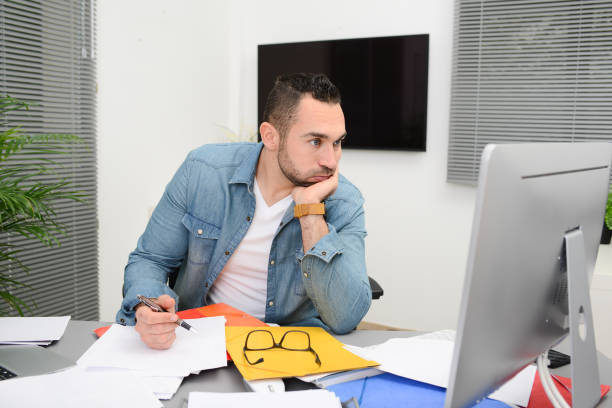 istock handsome man in office busy stressed headache paperwork burnout 1202968352
