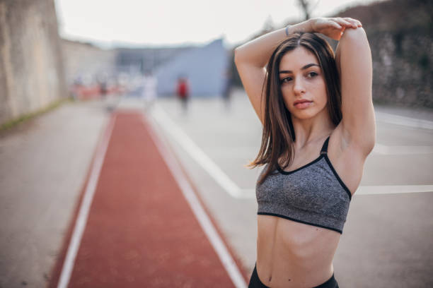 une jeune adolescente s'étirant - track and field athlete women vitality speed photos et images de collection