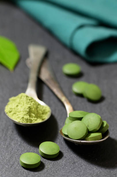 istock Chlorella And Barley Powder On Spoons on ardesia plate 1202969771