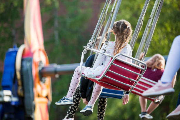 istock Little girl having fun on chain carousel. 1202971902