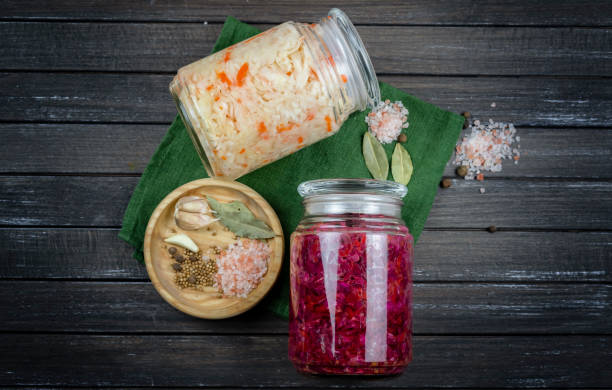 istock glass jars of fermented white, red cabbage, spices, salt. vegetables on a dark background. using textile green. fermentation is a source of probiotic. popular vegetarian food. copy space 1202971968