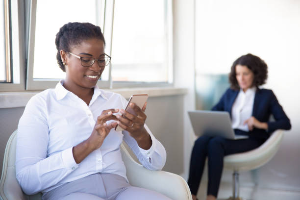 istock Smiling young businesswoman using smartphone 1202972315