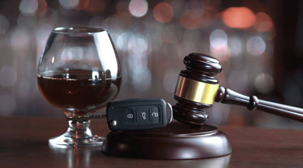 Drinking alcohol on driving ability The concept of a DUI. Law hammer, alcohol and car keys on wooden table, dark background driving under the influence stock pictures, royalty-free photos & images