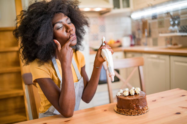 istock Afro women decorating a cake at home 1202975886