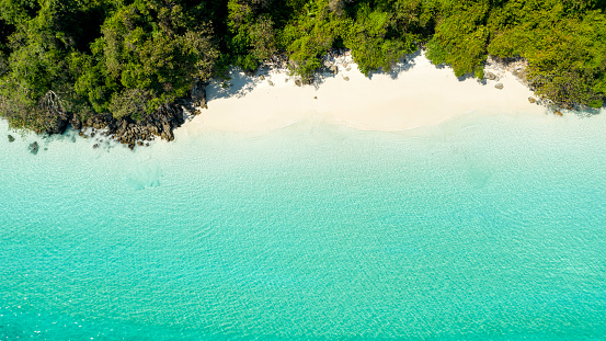 Aerial view of ocean waves, beach and rocky coastline and beautiful forest. Nyaung Oo Phee Island Myanmar. Space for entering text