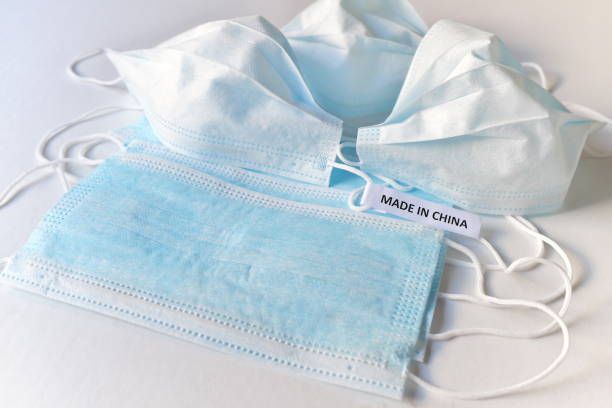 istock Surgical face masks with Made in China tag. Wuhan novel coronavirus outbreak, spread and transmission 1202979113