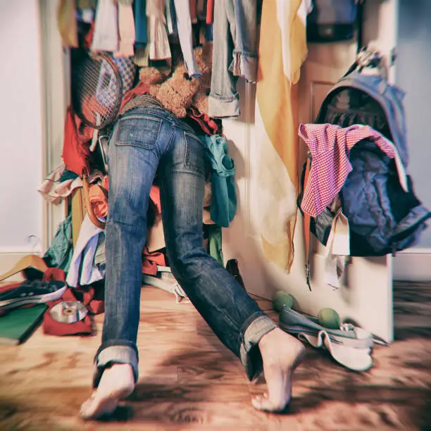 Woman searching in messy closet.