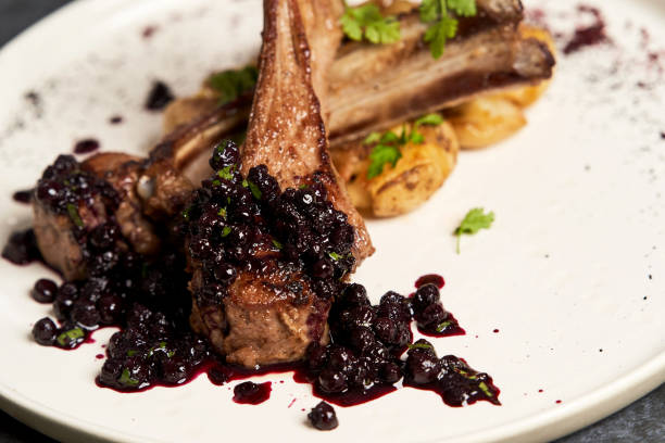 istock Lamb ribs with baked potatoes on a white plate, close-up. 1202981850