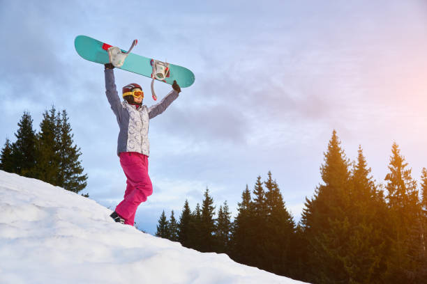 istock Girl with snowboard in snowy mountains 1202985204