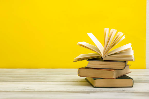 istock Open book, hardback books on wooden table. Back to school. Copy space. 1202985426