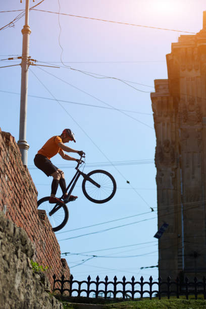 istock Freestyle biker jumping on a brick wall 1202986038
