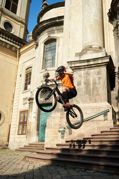 istock Man in sportswear jumping from steps on a bicycle. 1202986067