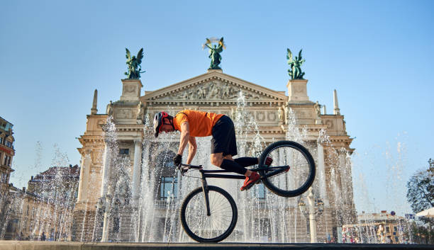 istock Athlete is cycling downtown near fountain. 1202986143
