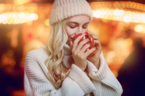mujer joven disfrutando de una taza de café caliente - mulled wine christmas tea heat fotografías e imágenes de stock