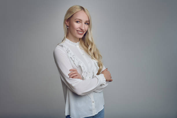 istock Young smiling blond woman with her arms folded 1202988622