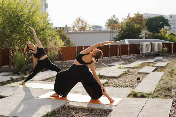 istock Two young girls practicing stretching and yoga workout exercise together 1202990991