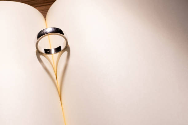 istock Heart shape shadow with the ring on middle the empty book. Valentine and every day of love concept. 1202995304