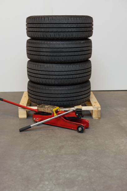 istock Close up view of car tires set and red jack. Car concept. 1203003708