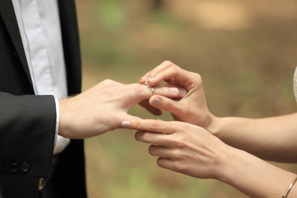 istock close, up., bride, putting, wedding, ring, grooms, finger. 1203004858