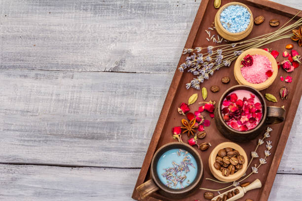 istock Set of romantic colored coffee latte for two lovers. Lavender and rose, powdered aromatic sugar, spices. Valentines Day concept. Tray, wooden boards background 1203005336