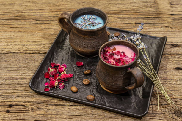 istock Set of romantic colored coffee latte for two lovers. Lavender and rose, powdered aromatic sugar, spices. Valentines Day concept. Wooden boards background 1203007545