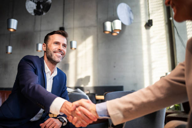 istock Business people shaking hands during meeting in cafe 1203009205