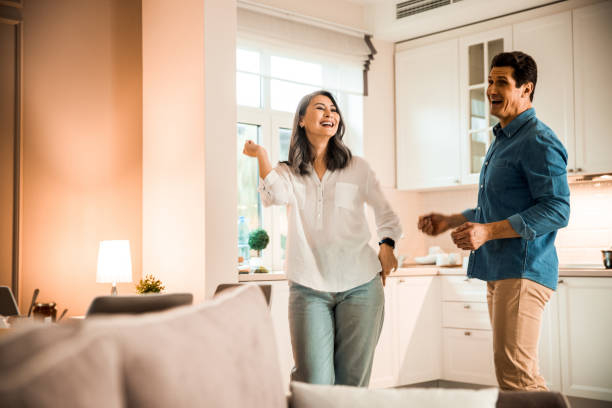 istock Happy woman dancing with her husband in the kitchen 1203012894