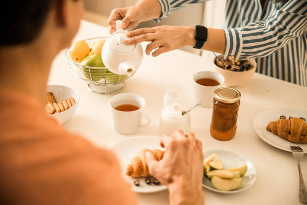 istock Lady is pouring tea to man at home 1203013553