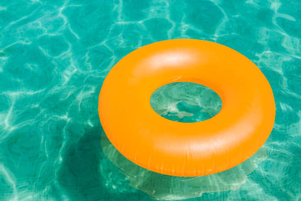 istock orange inflatable donut on blue water in a swimming pool. Summer 1203013751