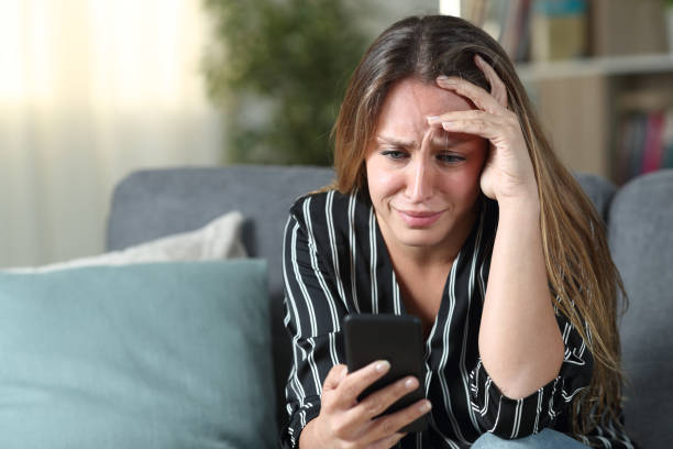 istock Sad housewife checking mobile phone at home 1203015031