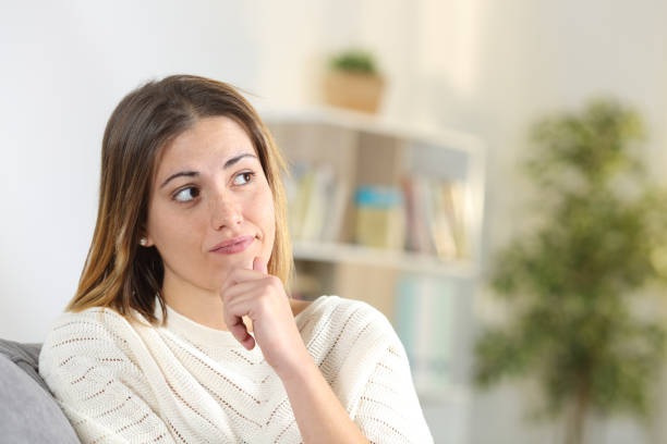 istock Woman wondering looking at side at home 1203015154