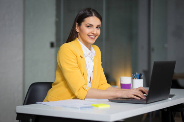 istock Businesswoman working on laptop late after work while looking at camera 1203015220