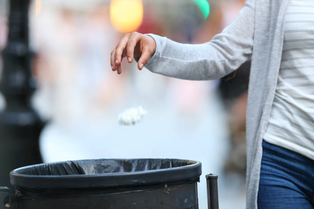 istock Woman hand throwing garbage to bin at evening 1203015382