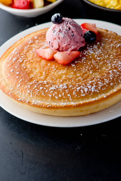 istock Pancakes, topped with fresh fruits and maple syrup 1203015589