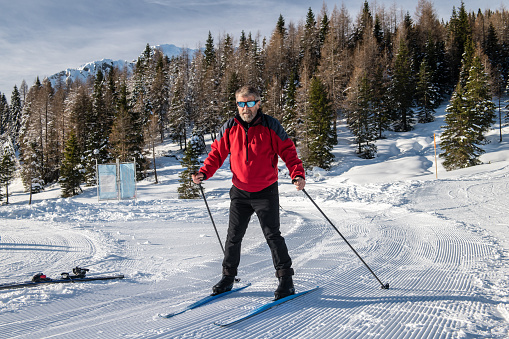 Caucasian man 65+ cross country skiing near Italy-Austria border, Europe. Nikon D850.