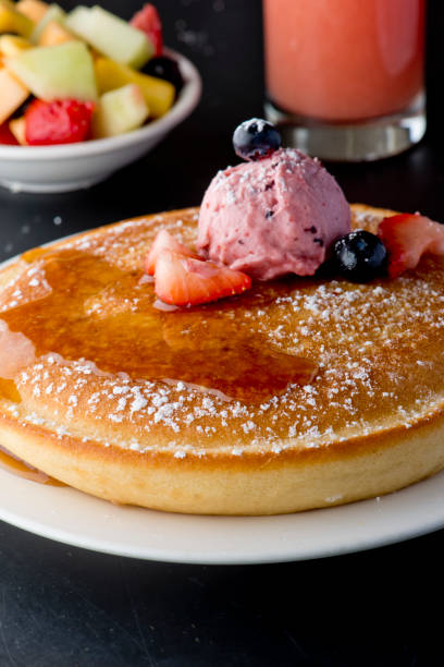 istock Pancakes, topped with fresh fruits and maple syrup 1203015637