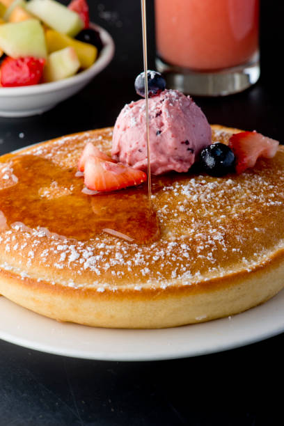 istock Pancakes, topped with fresh fruits and maple syrup 1203015704