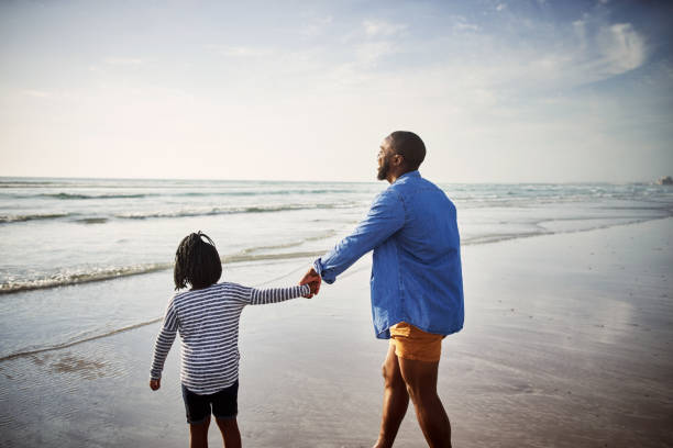 Shot of a young man spending time at the beach with his adorable daughter