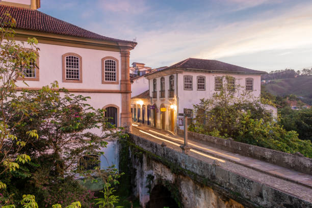 Beautiful landscape of colonial style buildings and old bridge in a cloudy sunset in Ouro Preto, Brazil. Ouro Preto was designed a World Heritage Site by UNESCO in 1980 because of its outstanding Baroque Portuguese colonial architecture. hermoso paisaje de edificios de estilo colonial y puente antiguo en una puesta de sol nublada en ouro preto, brasil. ouro preto fue diseñado patrimonio de la humanidad por la unesco en 1980 debido a su excepcional arquitectura colonial barroca portuguesa.