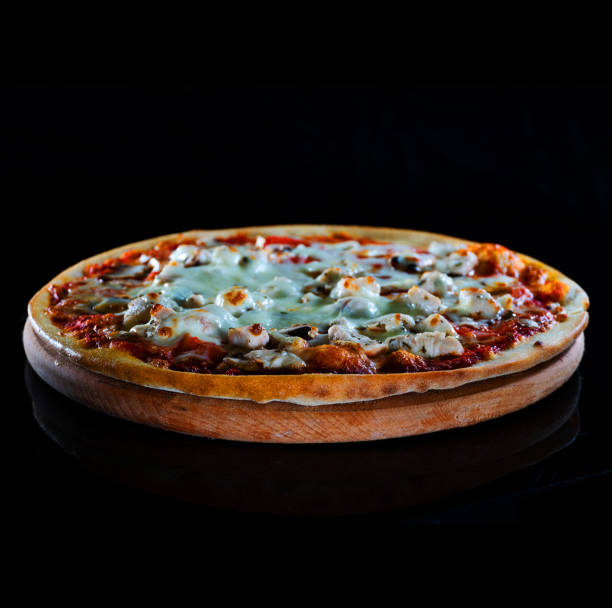 istock Italy hot pizza with chicken, tomatoes and cheese isolated on black background 1203020003