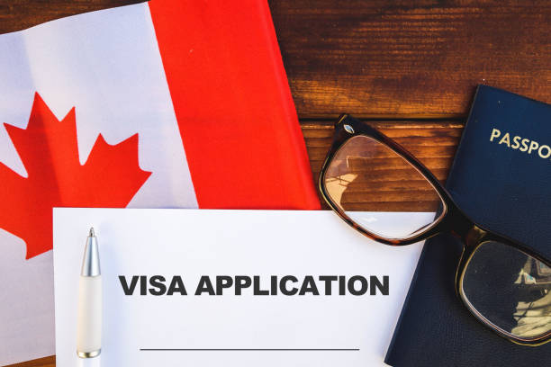 Canada visa application Flag of Canada, visa application form and passport on table embassy photos stock pictures, royalty-free photos & images