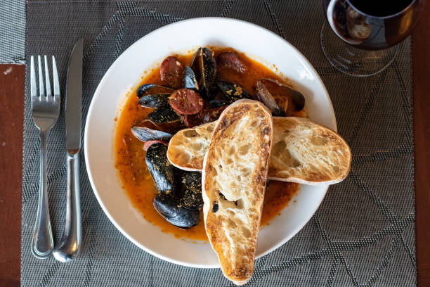 PEI Mussels PEI Mussels in red sauce with sourdough bread and red wine dre stock pictures, royalty-free photos & images