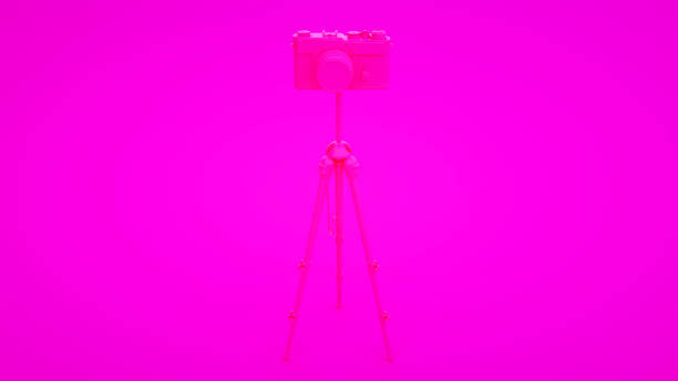istock Photo studio concept. Camera and tripod on pink background. 3d illustration 1203024355