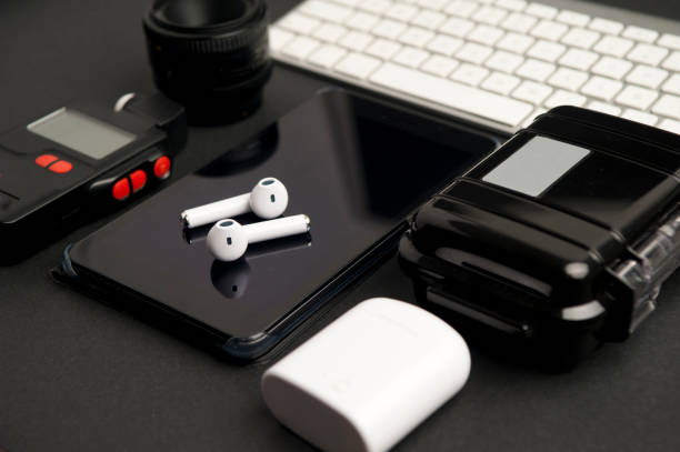 istock office work table, photography accessories, camera lens, with photometer, electronic phone book with headphones on top, white computer keyboard, black waterproof case white charger 1203027040