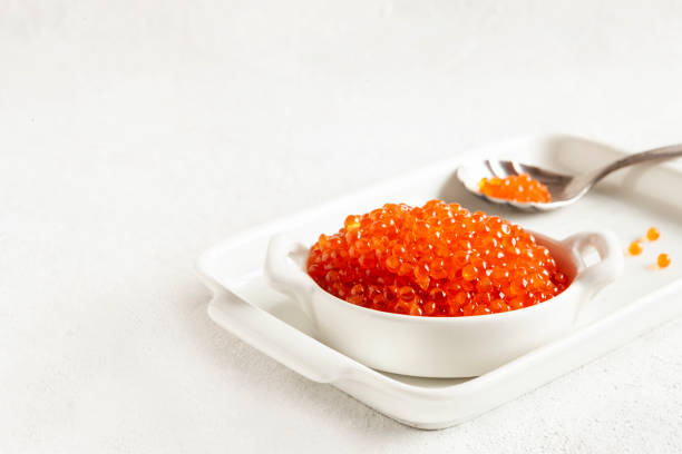 istock Trout caviar in a white bowl on a white background. 1203027775