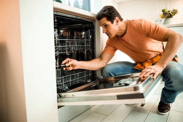 istock Male worker using screwdriver to repair dishwasher 1203027810