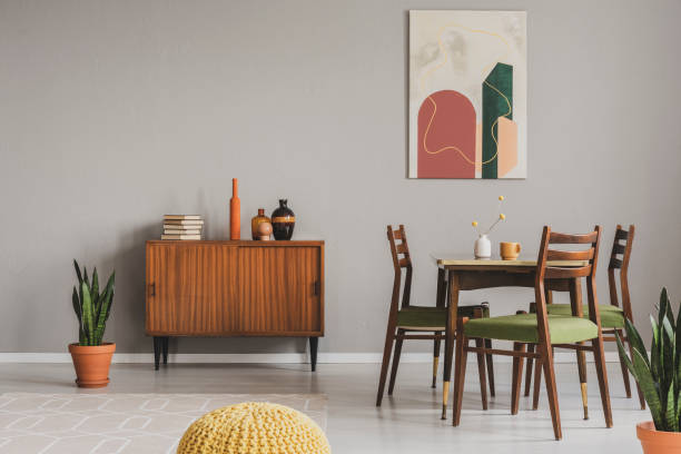 Vintage grey dining room with abstract paintings and wooden cupboard