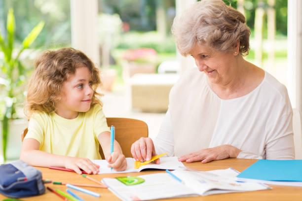 istock Smiling grandmother drawing with crayons with a young grandson 1203029011