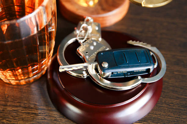 Drinking alcohol on driving ability The concept of a DUI. Law hammer, alcohol and car keys on wooden table, dark background driving under the influence stock pictures, royalty-free photos & images