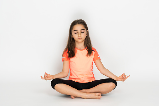 little girl doing yoga meditation exercise